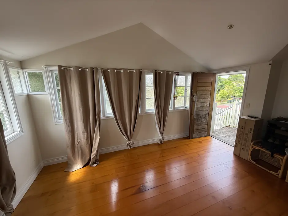 A lounge room before Guardian, its windows hung with drawn curtains